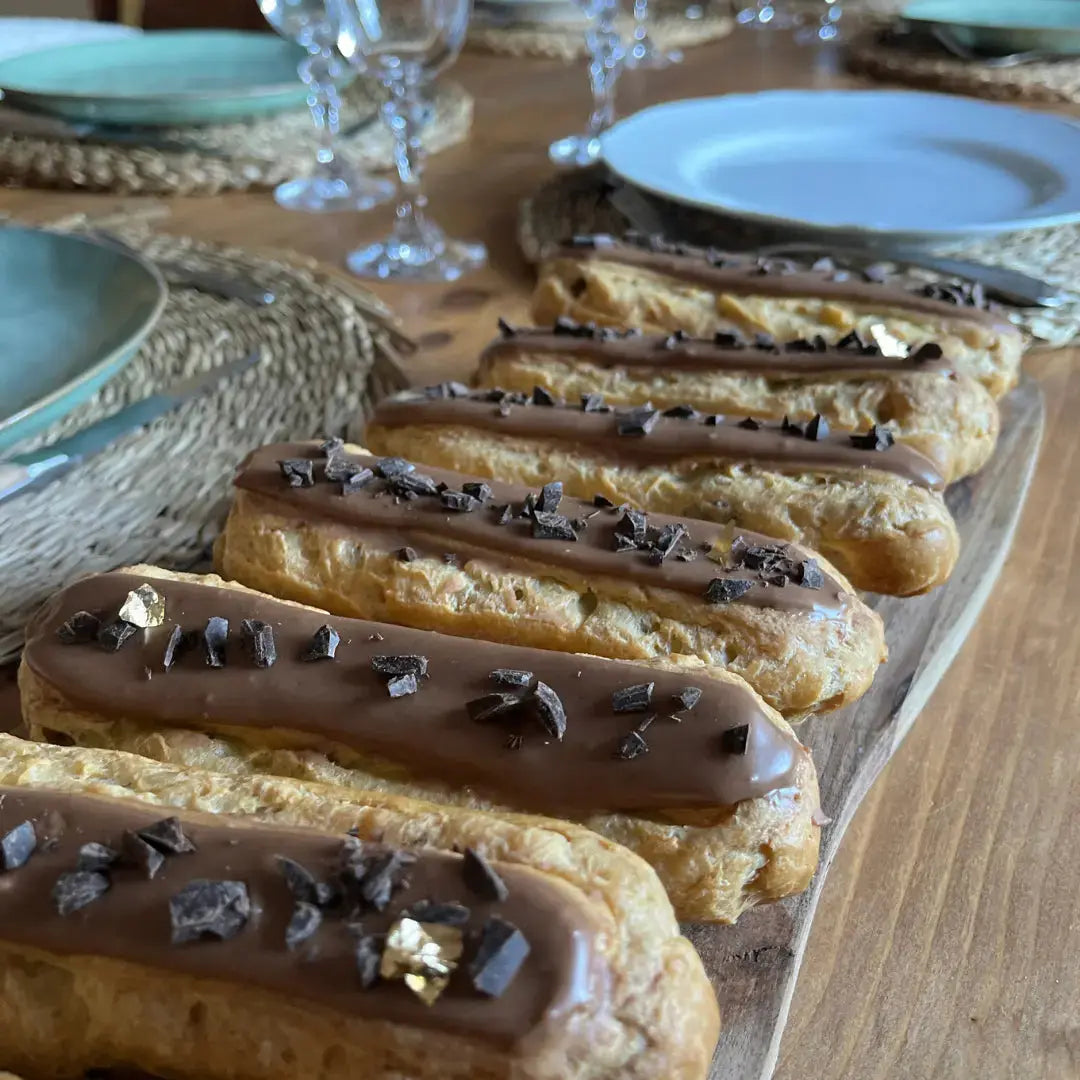 éclairs au chocolat présentés sur une table dressée